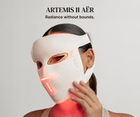 Woman wearing the RENPHO ARTEMIS II Aër red light therapy mask, glowing red across the face and neck