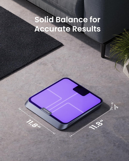 An Elis Chroma Smart Scale by Renpho with a purple glass surface is placed on a light grey floor next to a dark grey rug and a grey couch. Dimensions of 11.8" by 11.8" by 1.4" are displayed around it, and the text "Solid Balance for Accurate Results" is written above the scale. A green plant is partially visible in the background.