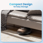 An advertisement image featuring a Renpho Shiatsu Foot Massager Compact in a dark metallic finish, stored neatly under a bed with beige and patterned bedding, on a light-colored carpet. Text reads