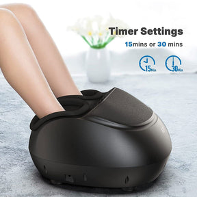 A person using a modern, sleek Renpho Shiatsu Foot Massager Premium (Remote) with timer settings displayed for 15 and 30 minutes. The scene includes a softly focused background with light blue tones and a vase of flowers. (A)